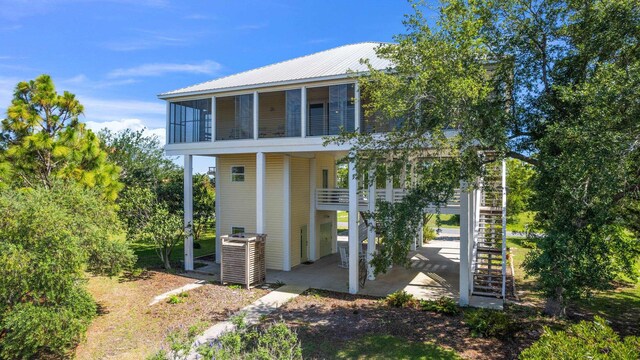 82 Royster Dr, Crawfordville, FL 32327 - rear view of property featuring stairs, a balcony, a patio area, cooling unit, and metal roof