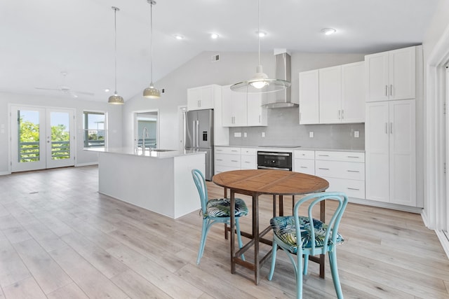 82 Royster Dr, Crawfordville, FL 32327 - kitchen featuring wall chimney range hood, stainless steel fridge, wall oven, ceiling fan, and a sink