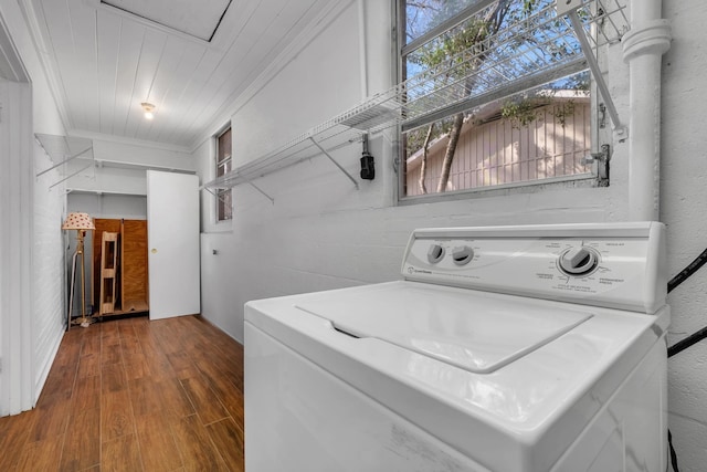 clothes washing area with crown molding, wood-type flooring, and washer / dryer