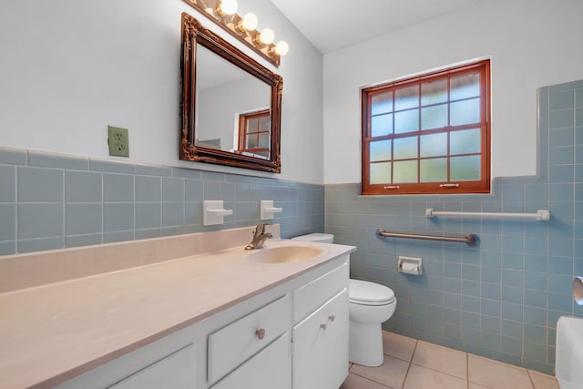 bathroom featuring vanity, tile walls, tile patterned floors, and toilet