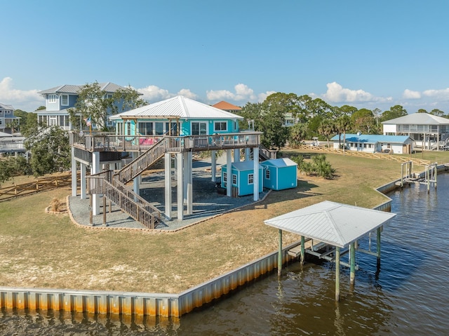 exterior space featuring a deck with water view and a lawn