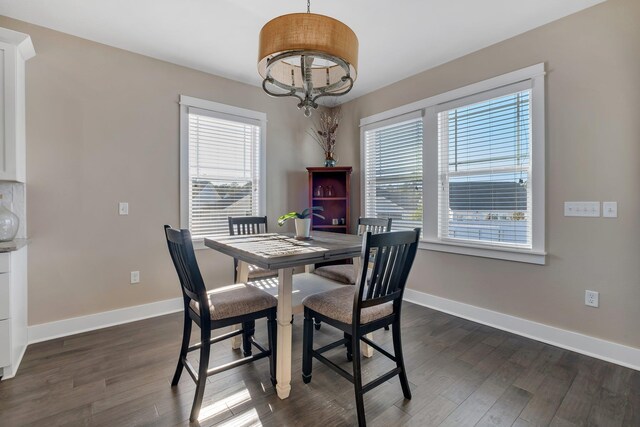 dining room with dark hardwood / wood-style flooring and a chandelier