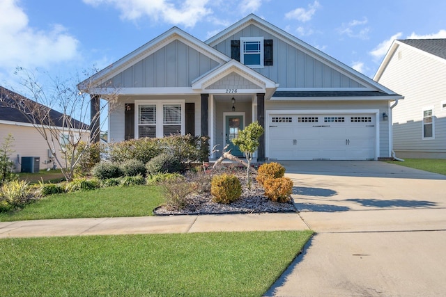 craftsman-style home with a front lawn, a garage, central air condition unit, and covered porch