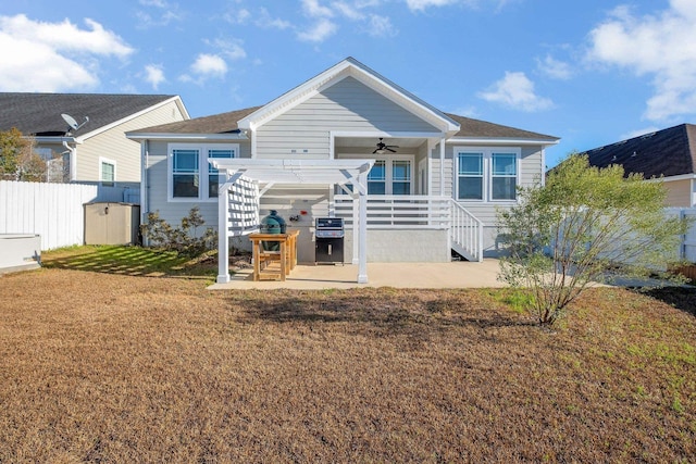 back of property with a patio area, a shed, ceiling fan, a yard, and a pergola