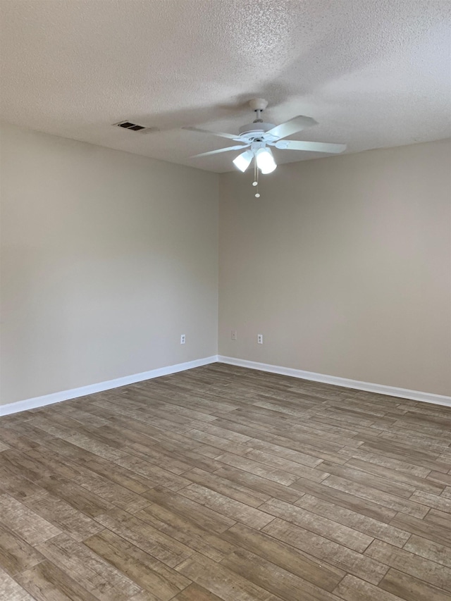 unfurnished room with ceiling fan, a textured ceiling, wood finished floors, and baseboards