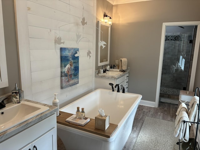 322 Graceland Rd, Chattahoochee, FL 32324 - bathroom featuring two vanities, a stall shower, a sink, wood finished floors, and a soaking tub
