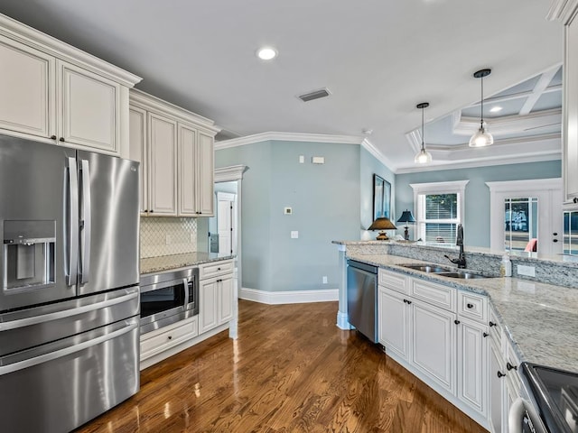 kitchen featuring pendant lighting, sink, appliances with stainless steel finishes, backsplash, and dark hardwood / wood-style floors