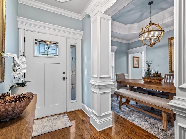 entryway with a notable chandelier, crown molding, wood-type flooring, and ornate columns