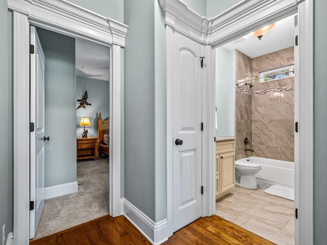 full bathroom featuring tiled shower / bath, vanity, and toilet