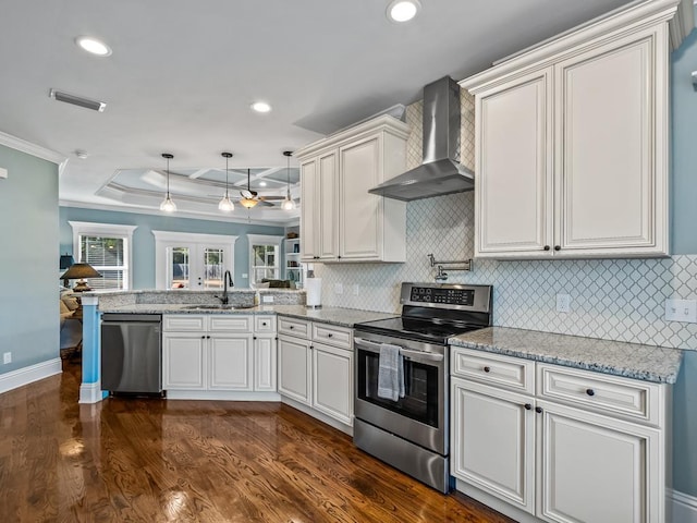 kitchen with appliances with stainless steel finishes, dark hardwood / wood-style flooring, kitchen peninsula, wall chimney range hood, and backsplash