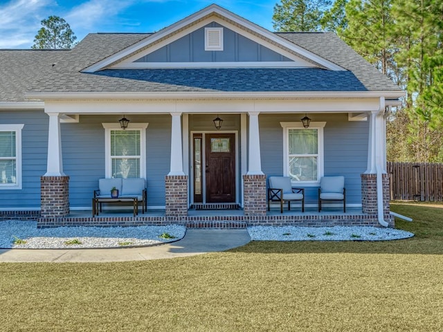 doorway to property with a yard and covered porch