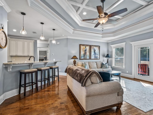 living room with dark hardwood / wood-style floors, sink, ornamental molding, coffered ceiling, and ceiling fan