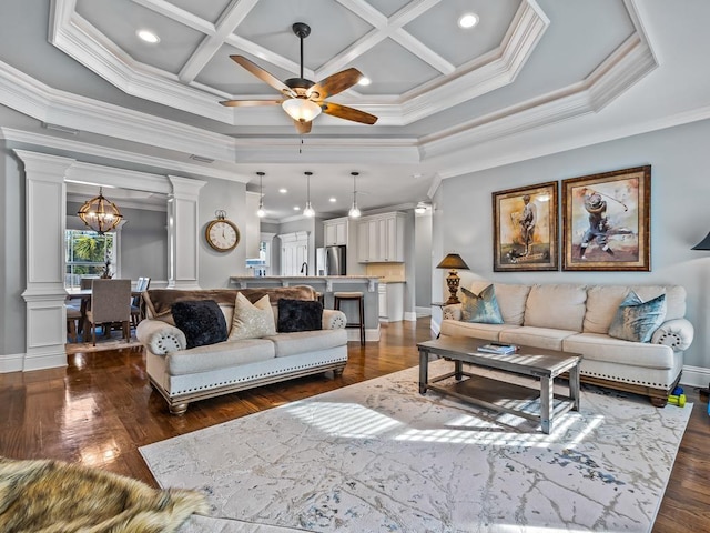 living room with ornate columns, ceiling fan with notable chandelier, dark hardwood / wood-style flooring, coffered ceiling, and crown molding