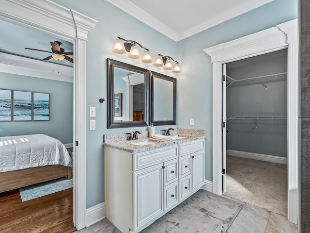 bathroom with crown molding, vanity, and ceiling fan