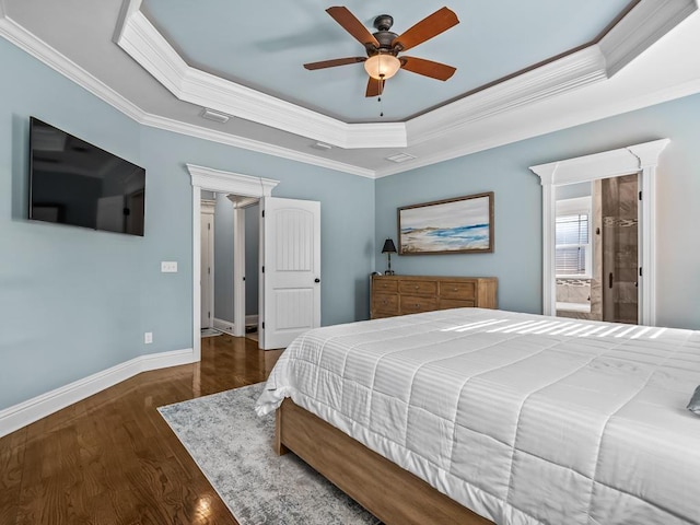 bedroom with crown molding, a tray ceiling, dark hardwood / wood-style floors, and ceiling fan