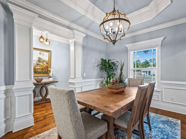 dining area with a notable chandelier, decorative columns, and dark hardwood / wood-style floors