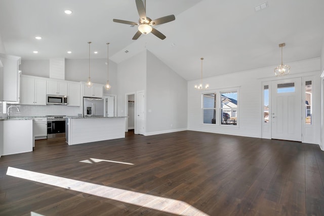 unfurnished living room with high vaulted ceiling, sink, ceiling fan with notable chandelier, and dark hardwood / wood-style flooring