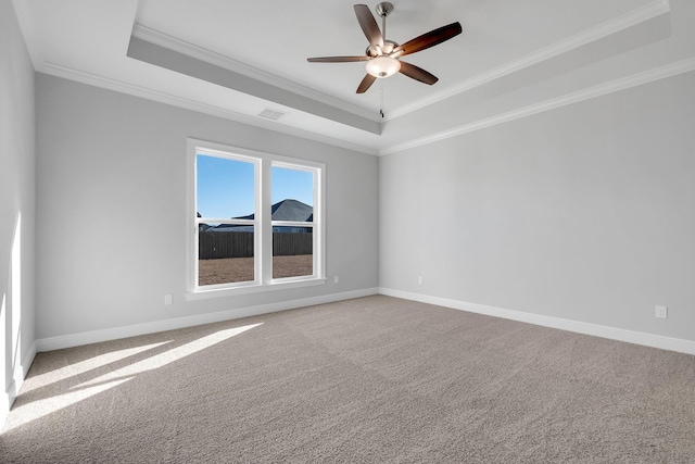 empty room featuring crown molding, a tray ceiling, ceiling fan, and carpet flooring