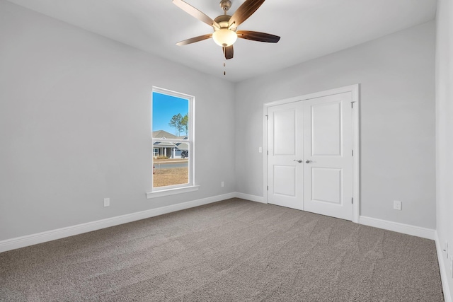 unfurnished bedroom featuring a closet, ceiling fan, and carpet