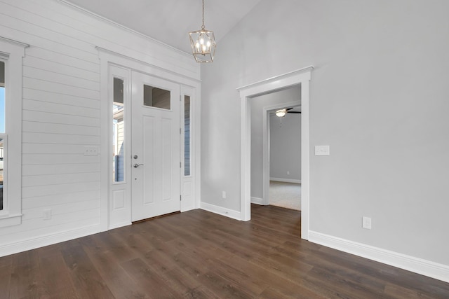 entrance foyer with lofted ceiling, dark hardwood / wood-style floors, and a chandelier