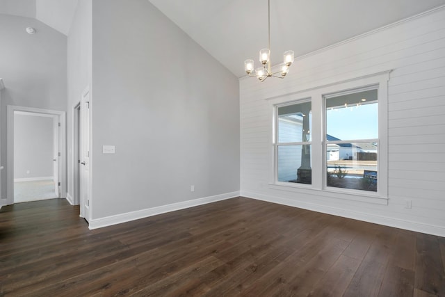 spare room with dark hardwood / wood-style floors, a notable chandelier, and high vaulted ceiling