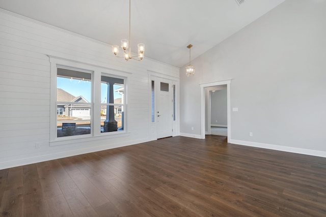 empty room featuring dark hardwood / wood-style floors, high vaulted ceiling, and a notable chandelier