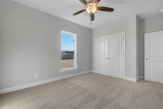 unfurnished bedroom with carpet floors, ceiling fan, and a closet