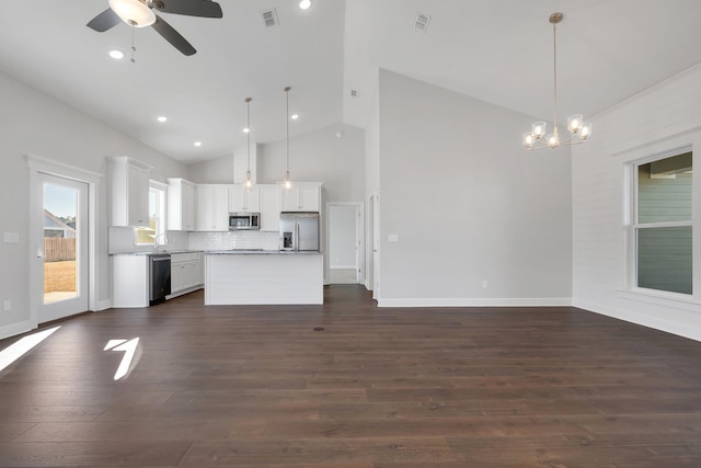 kitchen featuring a kitchen island, appliances with stainless steel finishes, decorative light fixtures, white cabinets, and backsplash