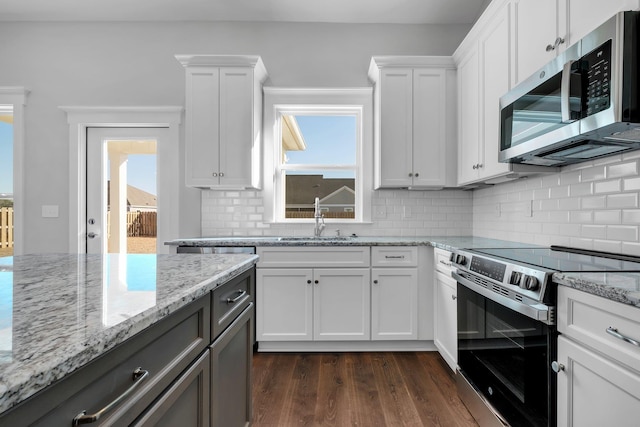 kitchen featuring sink, white cabinetry, tasteful backsplash, appliances with stainless steel finishes, and dark hardwood / wood-style floors