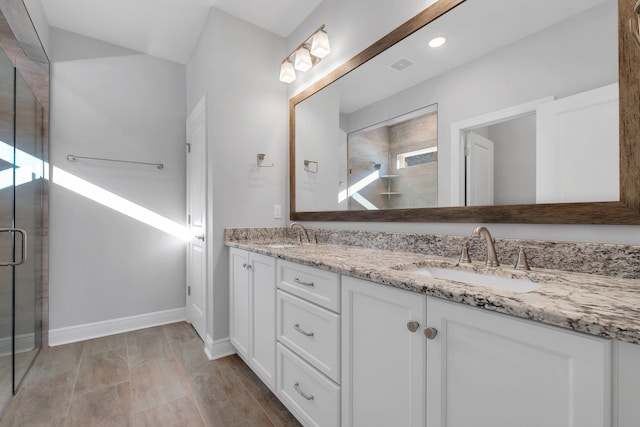 bathroom featuring vanity and a shower with shower door