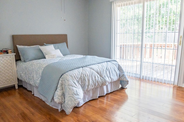 bedroom with access to exterior and wood finished floors