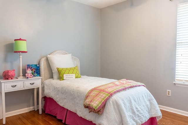 bedroom with wood finished floors and baseboards