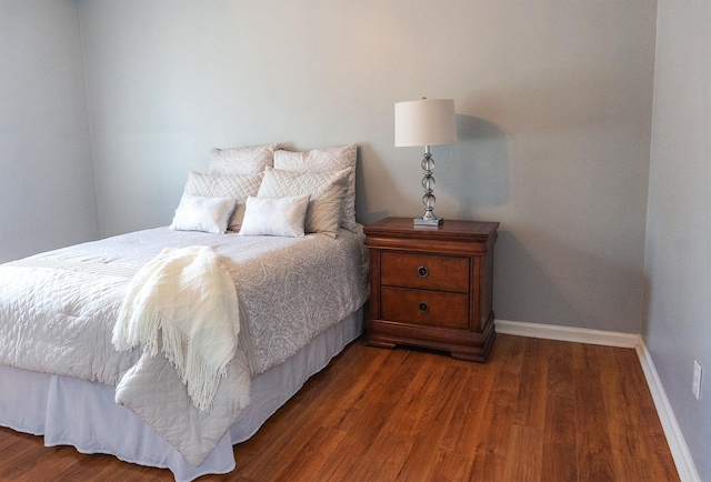 bedroom featuring baseboards and wood finished floors