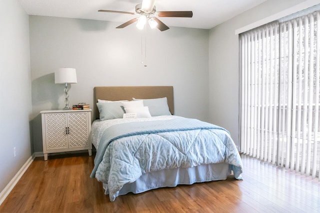 bedroom featuring ceiling fan, baseboards, and wood finished floors