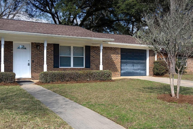 ranch-style house featuring an attached garage, driveway, a front yard, and brick siding