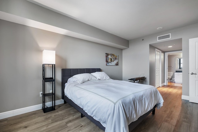 300 S Duval St # 1408, Tallahassee, FL 32301 - bedroom featuring wood finished floors, baseboards, and ensuite bathroom
