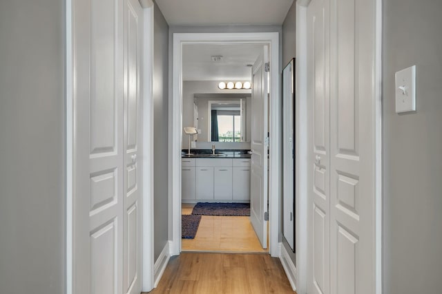 300 S Duval St # 1408, Tallahassee, FL 32301 - hall featuring a sink, light wood-type flooring, and baseboards