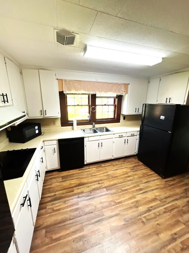 16619 SW Gaskin St, Blountstown, FL 32424 - kitchen featuring black appliances, a sink, light countertops, white cabinets, and light wood-style floors