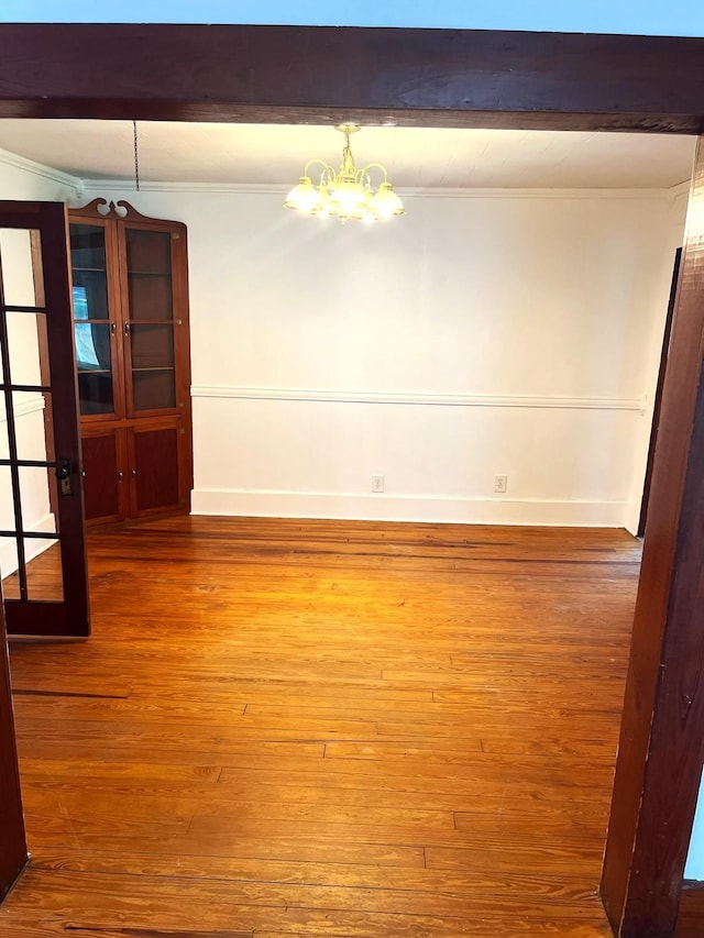 16619 SW Gaskin St, Blountstown, FL 32424 - unfurnished dining area with a chandelier, crown molding, wood finished floors, and baseboards