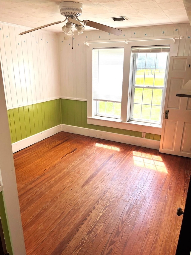 16619 SW Gaskin St, Blountstown, FL 32424 - unfurnished room featuring wood finished floors, healthy amount of natural light, ceiling fan, and wood walls