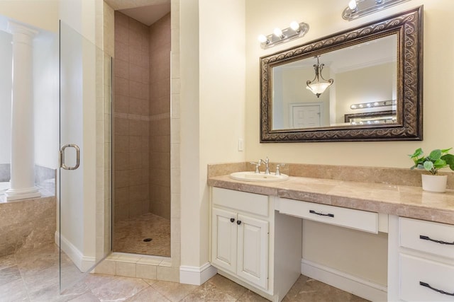 bathroom with decorative columns, vanity, and a shower with door