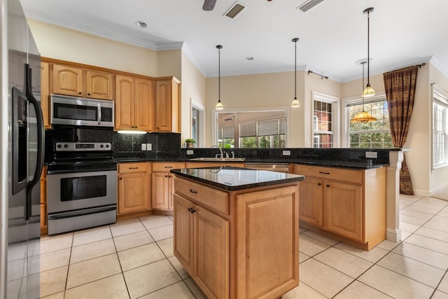 kitchen with pendant lighting, appliances with stainless steel finishes, sink, and a center island