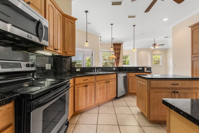 kitchen with light tile patterned flooring, decorative backsplash, crown molding, and stainless steel appliances