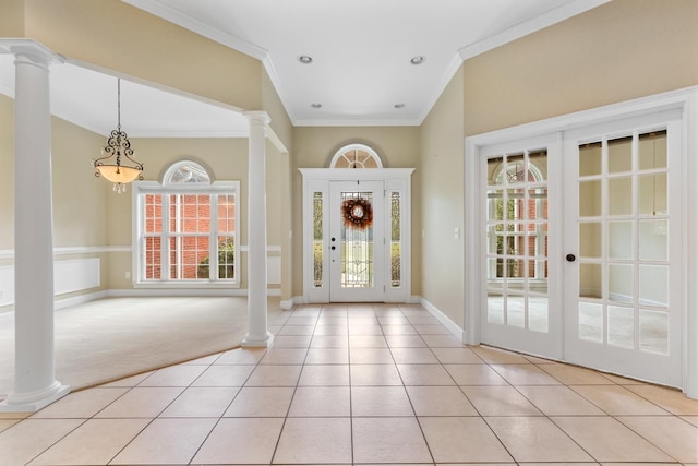 foyer entrance featuring decorative columns, french doors, light carpet, and crown molding