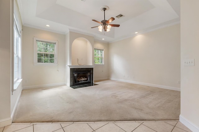 unfurnished living room featuring light carpet, crown molding, and a tray ceiling