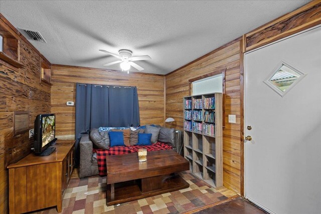 2056 N Sam Poppell Rd, Perry, FL 32347 - living area with wood walls, ceiling fan, and a textured ceiling