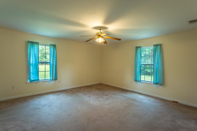 empty room featuring ceiling fan, a healthy amount of sunlight, and carpet flooring