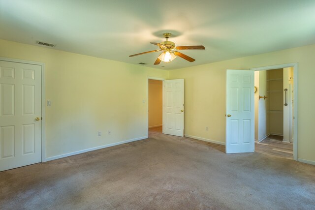 unfurnished bedroom featuring light colored carpet and ceiling fan