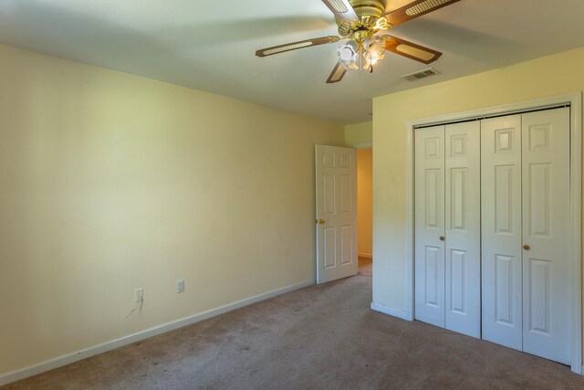 unfurnished bedroom with a closet, light colored carpet, and ceiling fan