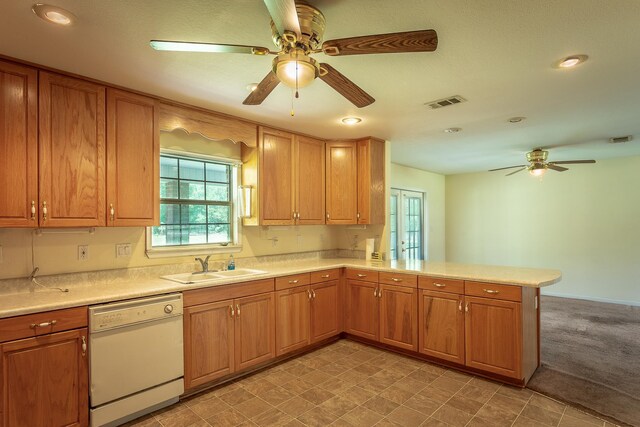 kitchen featuring light colored carpet, dishwasher, kitchen peninsula, sink, and ceiling fan